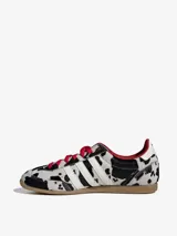 Championes Adidas modelo Japan W con diseño de estampado animal print tipo dálmata en pelo sintético. Presenta las tres franjas laterales en blanco, cordones rojos, forro interior rojo y suela de goma color caramelo.