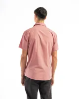 Camisa de manga corta color celeste claro, confeccionada en algodón, con cuello clásico y un bolsillo de parche en el lado izquierdo del pecho.