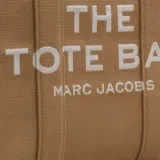 Bolso tote grande de Marc Jacobs, confeccionado en tejido jacquard con diseño estructurado. Presenta el texto 'THE TOTE BAG' y 'MARC JACOBS' en contraste en el frente, cierre superior con cremallera y asas dobles reforzadas.