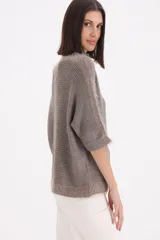 Sweater de tejido de punto con terminaciones de flecos en el cuello, mangas y ruedo. Presenta un corte holgado, mangas tres cuartos y una costura central vertical.