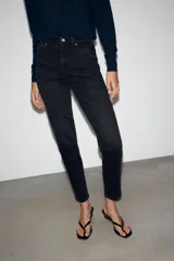 Jeans mom fit de tiro alto color negro con efecto lavado, diseño de cinco bolsillos y corte tobillero.