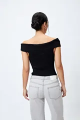 Top tejido de punto acanalado color blanco, con escote bardot que deja los hombros al descubierto.