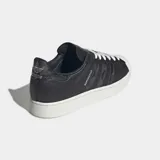 Championes Adidas Superstar II de color negro con la icónica puntera de caucho en relieve y suela blanca. Presenta detalles con estampado de piel de serpiente en las tres tiras laterales y en el talón, además de cordones blancos y el nombre del modelo en dorado.