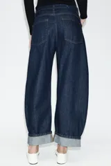 Jeans de tiro medio con diseño de pierna tipo balloon y corte full length. Presenta cintura con trabillas, cinco bolsillos clásicos, cierre frontal con cremallera y botón, y bajo acabado con vuelta.