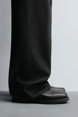 Bota de caña alta confeccionada en piel con acabado granulado y suela de goma con volumen a tono.