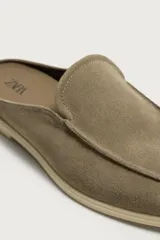 Mocasín destalonado de hombre fabricado en piel con acabado en gamuza, color marrón claro, con detalle de bordón en la parte superior, horma redonda y suela plana a contraste.