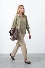 Camisa de manga larga en color celeste, con diseño de corte relajado, cuello clásico y detalle de tablas verticales en el frente.