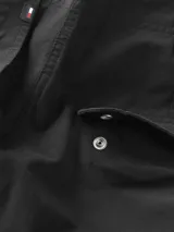 Pantalón cargo negro de corte cónico y talle alto, con cierre de cremallera y botón, bolsillos de parche ribeteados en la cintura y bolsillos tipo cargo.