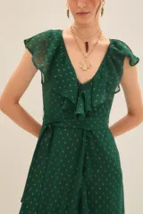 Vestido largo con estampado floral en tonos fucsia, negro y dorado, con escote en V cruzado, mangas cortas y lazo en la cintura.