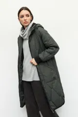 Campera de nylon larga oversized color negro, con capucha, tres bolsillos externos y uno interno. De tela capitoneada, con puños en las mangas y forro polar.