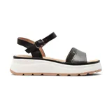 Sandalias de plataforma color negro y plateado, con tira delantera plateada y tira trasera negra con hebilla. Plataforma blanca con suela marrón.