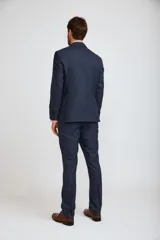 Ambo formal compuesto por saco de dos botones y pantalón de vestir a juego, en color azul marino. El saco presenta solapas clásicas y bolsillos con solapa, mientras que el pantalón tiene un corte recto y elegante.