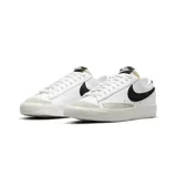 Championes Nike Blazer Low 77 de corte bajo, con capellada de cuero blanco, logo Swoosh lateral en negro y refuerzo de gamuza en la puntera. Presenta suela de goma con textura y lengüeta con espuma expuesta.