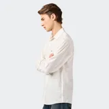 Camisa de manga larga color blanco, con cuello clásico, cierre con botones y bolsillo en el pecho con logo de la marca.