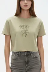 Remera cropped de algodón negra con cuello a la base, mangas cortas y estampado frontal de cerezas con la palabra "HELLO".