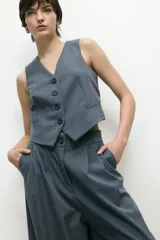 Chaleco sastrero negro con escote en V y cierre frontal con botones.