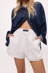 Short blanco de lino y algodón, con cintura elastizada y cordón ajustable.