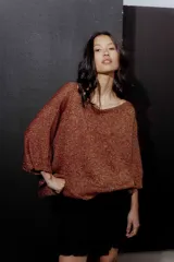 Buzo de hilo con tejido de punto fino, de corte holgado y mangas tres cuartos. Presenta un diseño versátil con cuello redondo amplio y acabado ligeramente brillante.