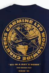 Remera azul marino de corte holgado con cuello redondo y estampado pequeño en el pecho con un avión y texto en color ocre.