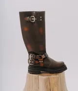 Bota alta estilo biker de cuero marrón con efecto desgastado, suela track de goma y detalles de hebillas metálicas en el tobillo y en la parte superior de la caña.