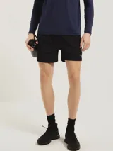 Short deportivo tipo runner color negro, confeccionado en tejido técnico de secado rápido. Presenta un corte corto, cintura elástica y logo reflectante en la pierna derecha.