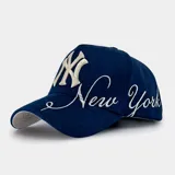 Gorra tipo baseball color azul marino con bordado frontal del logo de los New York Yankees y la inscripción New York en tipografía cursiva. Presenta visera curva y ajuste posterior.