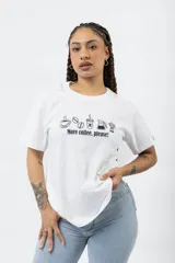 Remera blanca de algodón con estampa frontal en color negro que incluye iconos de café y la frase 'More coffee, please!'. Presenta cuello redondo y mangas cortas.
