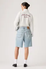Bermuda de jean tiro medio color celeste claro, estilo baggy con roturas y flecos en los bordes.
