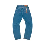 Pantalón de jean corte baggy en color azul lavado, con detalle de franja vertical en el bolsillo trasero derecho y parche de cuero en la cintura.