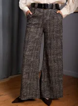Pantalon palazzo de tiro alto con estampado de espiga en tonos negro y beige. Presenta corte amplio, bolsillos laterales y presillas para cinturón.