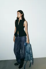 Top entallado rojo sin mangas, con cuello redondo y cierre frontal con cremallera oculta.