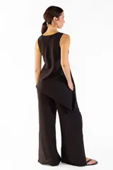 Pantalón ancho negro con bolsillos laterales, pretina elástica y cortes en los laterales que aportan movimiento. Confeccionado en mezcla de tencel y nylon.