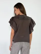 Blusa bordó de manga corta con escote en V y volados en cascada que rodean el cuello y el frente.