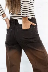 Jean de mujer de corte recto y tiro alto, con efecto degradado de negro a marrón. Presenta costuras verticales en la parte delantera y bolsillos laterales.