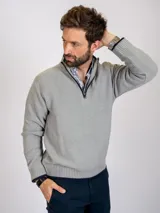 Sweater gris claro de tejido de punto con medio cierre frontal y cuello alto.