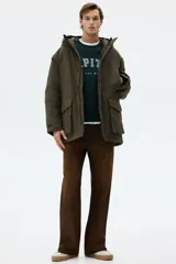 Campera parka acolchada repelente al agua y rompevientos, con cuello alto, capucha ajustable, cierre frontal con solapa y bolsillos frontales tipo parche y calientamanos.