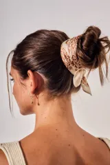 Bandana de poliéster color beige con estampado paisley en tonos marrones.