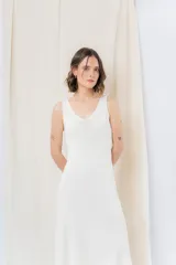 Vestido midi color crudo, de tejido acanalado, con escote en V y corte al cuerpo.