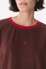 Remera de manga larga con corte oversized, color azul marino con cuello redondo en contraste color marrón. Presenta costuras decorativas a contratono hechas a mano en la zona de los hombros y logo bordado en el centro del pecho.