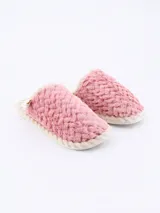 Pantuflas cerradas color rosa, con textura de pelo largo y suave, forro interior de color crema y borde de suela trenzado en color beige.