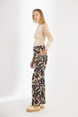 Pantalón de brocato con estampado de hojas de ginkgo en tonos azulados y beige, tiro medio y piernas rectas.