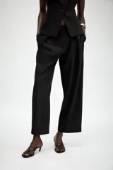 Pantalón de corte carrot con pinzas delanteras, tiro bajo y cierre frontal con cremallera y botón. Cuenta con bolsillos laterales y falsos bolsillos traseros de vivo.