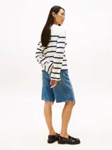 Remera de manga larga color blanco con rayas horizontales azul marino, cuello barco y botones dorados en los hombros.