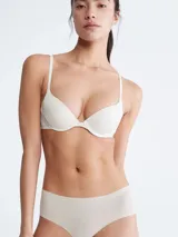 Bombacha hipster color beige de microfibra ligera con bordes cortados a láser y logo de Calvin Klein estampado en la cadera.