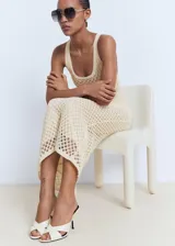 Vestido midi de crochet con diseño recto, cuello escotado y tirantes anchos. Cuenta con forro interior y tejido de punto calado.