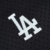 Remera de béisbol negra con textura de malla, cuello en V con botones y mangas cortas. Presenta el logo de Los Angeles Dodgers bordado en el pecho izquierdo y la inscripción Dodgers en el derecho.