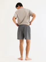 Pijama de hombre compuesto por una remera azul marino de cuello V y un short a cuadros en tonos azul, blanco y gris.