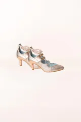 Zapato de tacón de 6 cm de alto color rosa nude, con cordones y borlas.