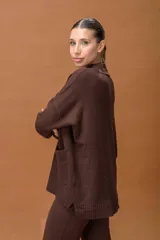 Conjunto de dos piezas tejido en color marrón chocolate, compuesto por un buzo de cuello alto con bolsillos frontales y un pantalón de corte recto y holgado.
