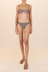 Top de bikini tipo corsetero verde oscuro con estampado geométrico de pinzas en rosa y blanco. Breteles delgados ajustables, copas con varilla y amarre en la espalda.